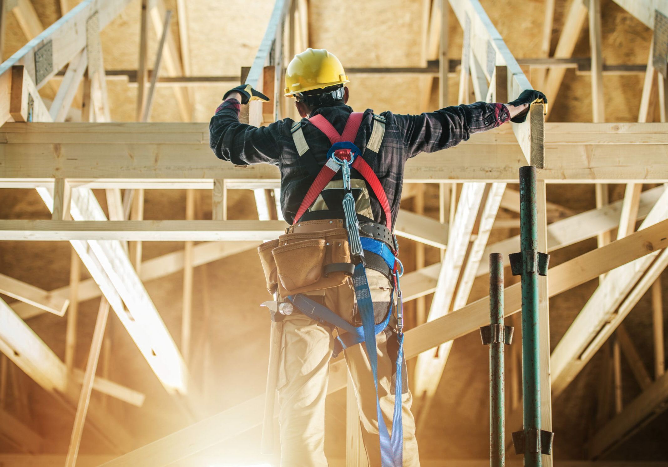 Skeleton House Frame Construction Worker Wearing Safety Harness Staying in Front on the Building and Preparing Himself For the Job.